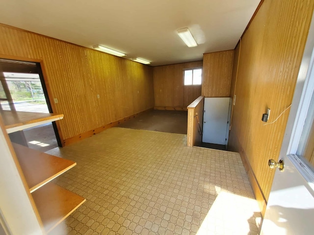 854 Kelley St, Traverse City, MI 49686 - below grade area featuring wooden walls, light flooring, a wall mounted air conditioner, and baseboards