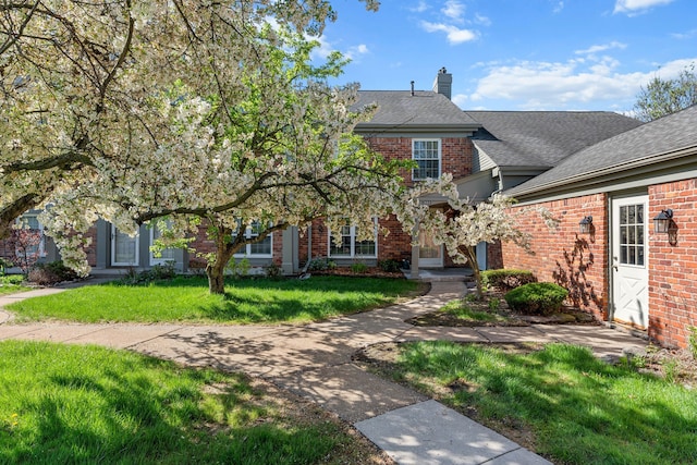 2658 Williamsburg Cir Unit 47, Auburn Hills, MI 48326 - view of front facade with brick siding, a front yard, a chimney, and roof with shingles