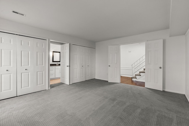 2658 Williamsburg Cir Unit 47, Auburn Hills, MI 48326 - unfurnished bedroom featuring carpet flooring, baseboards, two closets, and ensuite bathroom
