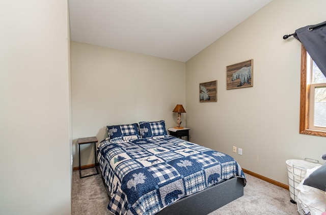 carpeted bedroom with vaulted ceiling and baseboards