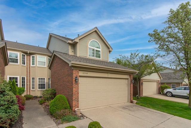traditional home featuring concrete driveway, brick siding, and an attached garage