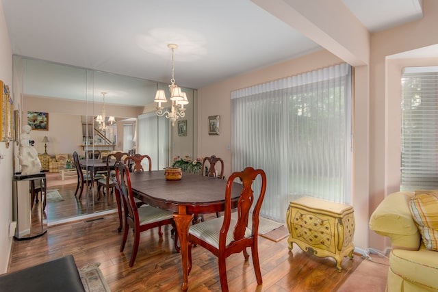 dining space featuring an inviting chandelier, hardwood / wood-style flooring, and a healthy amount of sunlight