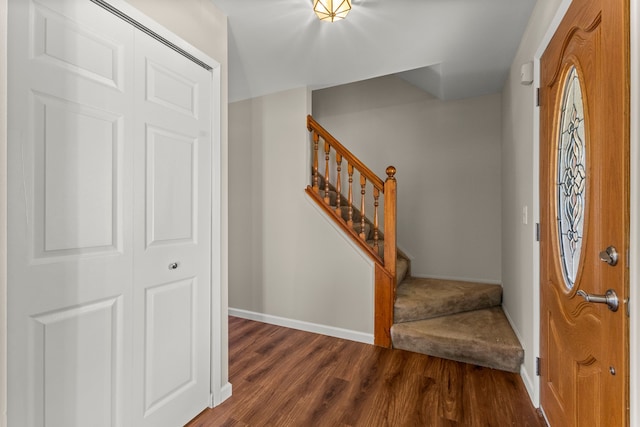 foyer entrance with baseboards, dark wood-type flooring, and stairs