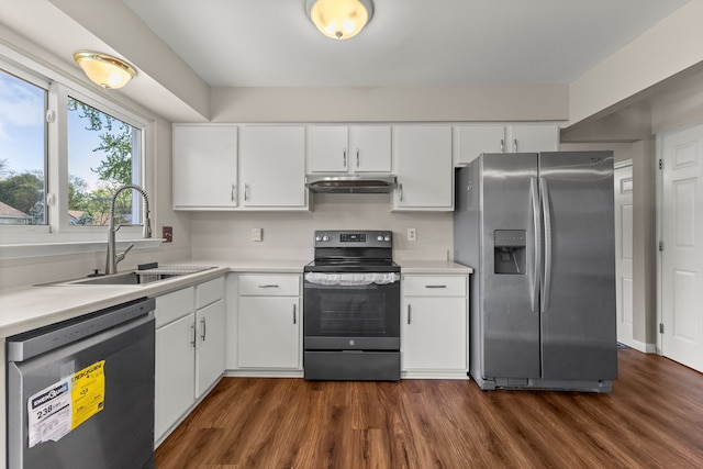 kitchen featuring appliances with stainless steel finishes, a sink, light countertops, dark wood finished floors, and white cabinetry