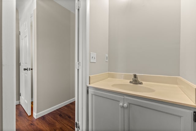 bathroom with wood finished floors, vanity, and baseboards