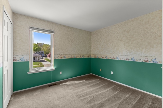 carpeted empty room featuring baseboards