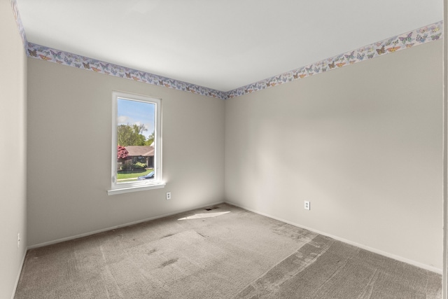 unfurnished room featuring carpet flooring and baseboards