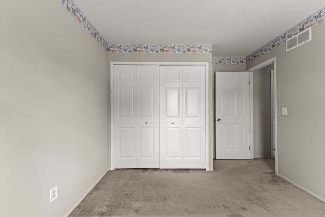 unfurnished bedroom featuring carpet, a closet, and baseboards