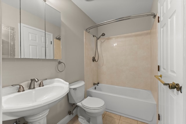 full bath with tile patterned floors, toilet, a sink, baseboards, and shower / washtub combination