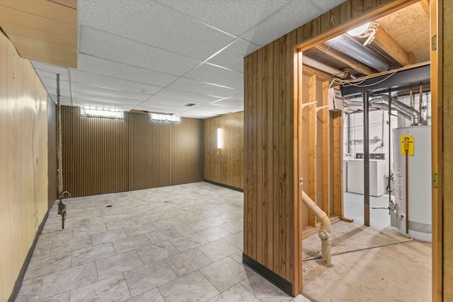 finished basement with gas water heater, separate washer and dryer, and wood walls
