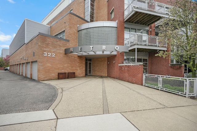 view of building exterior with fence and community garages