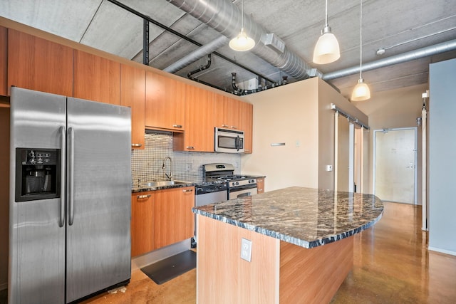 kitchen featuring appliances with stainless steel finishes, a sink, concrete flooring, a kitchen island, and tasteful backsplash