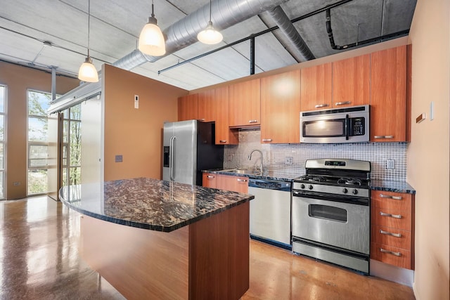 kitchen with appliances with stainless steel finishes, a sink, tasteful backsplash, and finished concrete floors