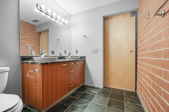 bathroom featuring toilet and double vanity