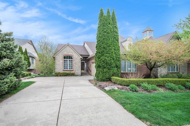 view of front of property featuring stone siding, concrete driveway, and a garage