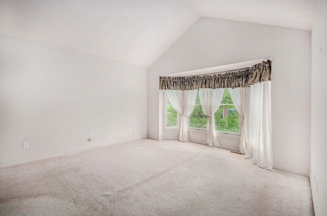 unfurnished room with carpet, baseboards, and high vaulted ceiling