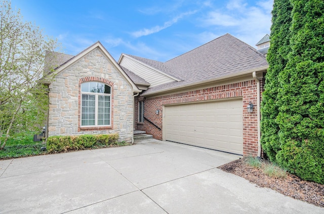 view of front of property featuring driveway, stone siding, roof with shingles, a garage, and brick siding