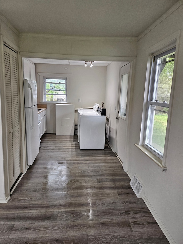 kitchen featuring freestanding refrigerator, dark wood-style flooring, ornamental molding, visible vents, and white cabinets