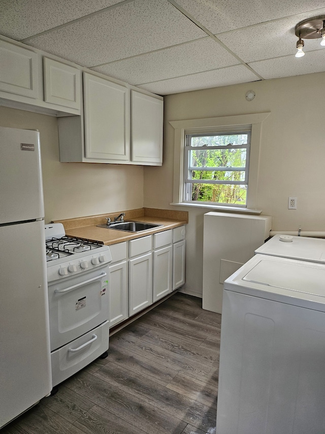 interior space featuring washing machine and clothes dryer, dark wood-style flooring, laundry area, and a sink
