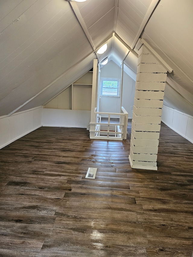 additional living space with vaulted ceiling and dark wood-style floors