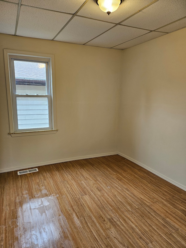 spare room featuring visible vents, wood finished floors, and baseboards