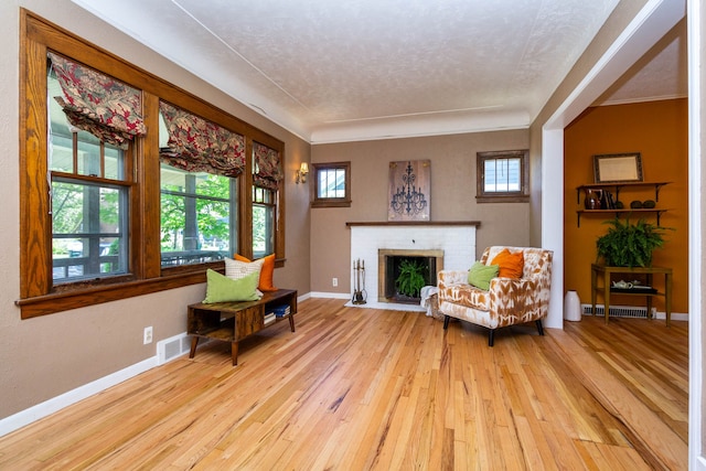 320 E Farnum Ave, Royal Oak, MI 48067 - living area with hardwood / wood-style flooring, a textured ceiling, baseboards, a brick fireplace, and ornamental molding