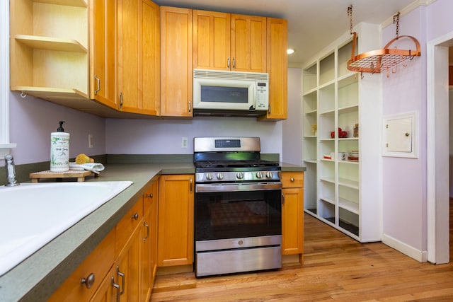 320 E Farnum Ave, Royal Oak, MI 48067 - kitchen featuring white microwave, stainless steel gas stove, open shelves, light wood-style floors, and a sink