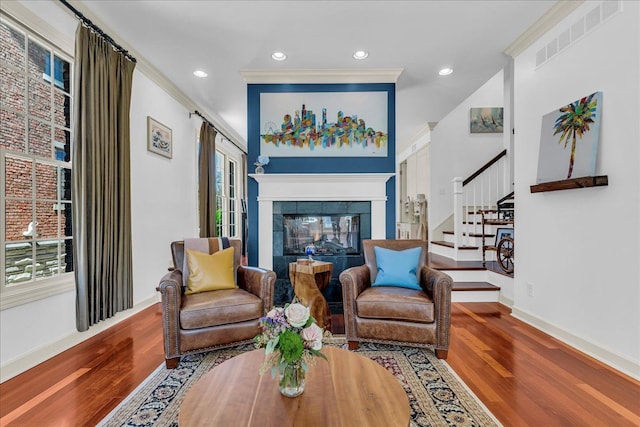 living area with wood finished floors, baseboards, stairs, plenty of natural light, and recessed lighting