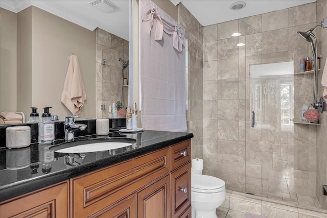 bathroom featuring a shower stall, toilet, vanity, and ornamental molding