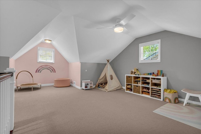 rec room with vaulted ceiling, carpet flooring, plenty of natural light, baseboards, and a ceiling fan