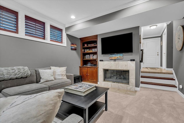 living room with crown molding, baseboards, a tile fireplace, light carpet, and built in shelves