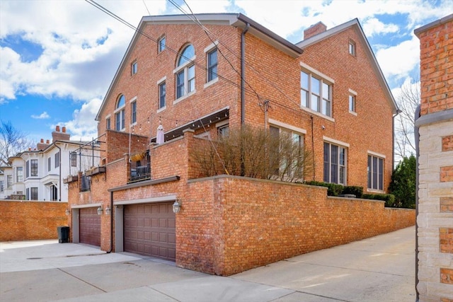 view of property featuring concrete driveway and an attached garage