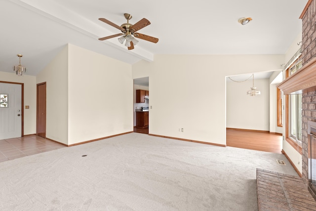 unfurnished living room featuring ceiling fan with notable chandelier, lofted ceiling with beams, visible vents, carpet floors, and baseboards