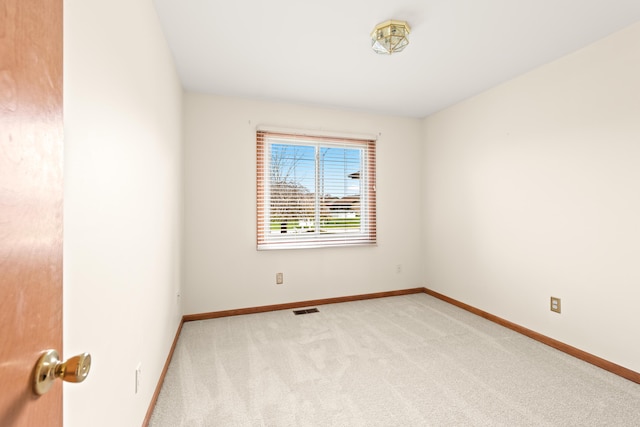 empty room featuring carpet floors, baseboards, and visible vents