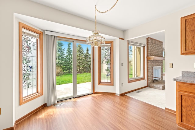 unfurnished dining area featuring a notable chandelier, baseboards, visible vents, and a wealth of natural light