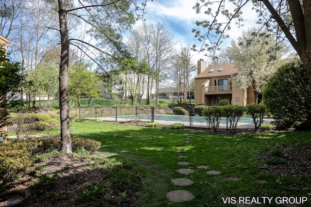 view of home's community featuring a yard, fence, and a pool