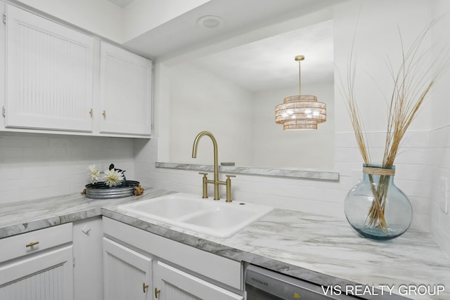kitchen with a sink, decorative light fixtures, white cabinetry, decorative backsplash, and light countertops