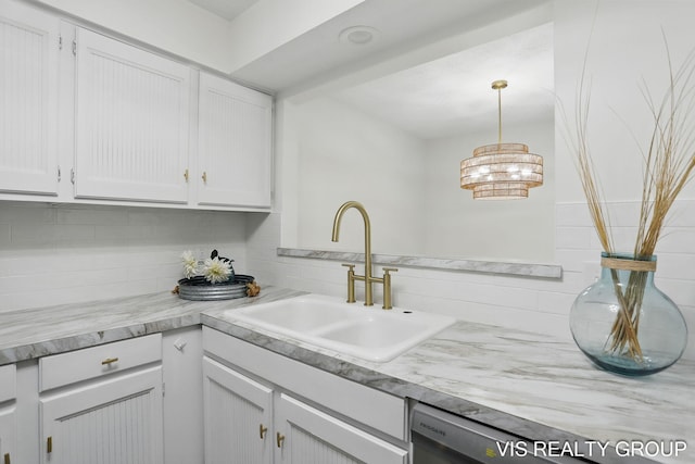 kitchen featuring decorative light fixtures, a sink, white cabinetry, light countertops, and tasteful backsplash