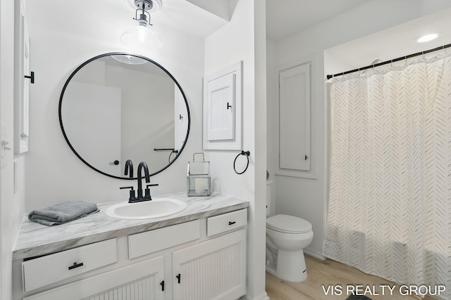 bathroom featuring toilet, a shower with curtain, vanity, and wood finished floors