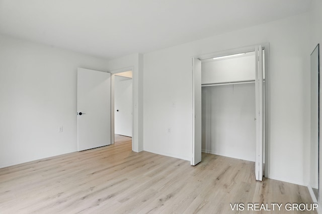 unfurnished bedroom featuring a closet and wood finished floors