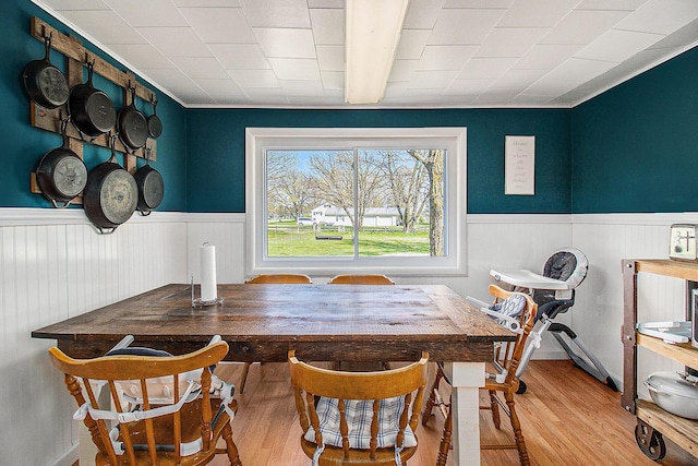 dining room with a wainscoted wall and wood finished floors