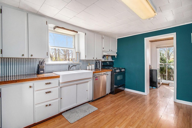 kitchen with a sink, gas range oven, stainless steel dishwasher, under cabinet range hood, and light wood-style floors