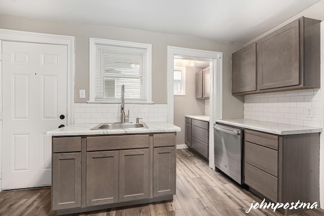 1108/1110 Muskegon Ave NW, Grand Rapids, MI 49504 - kitchen with a sink, stainless steel dishwasher, light countertops, light wood-style floors, and decorative backsplash