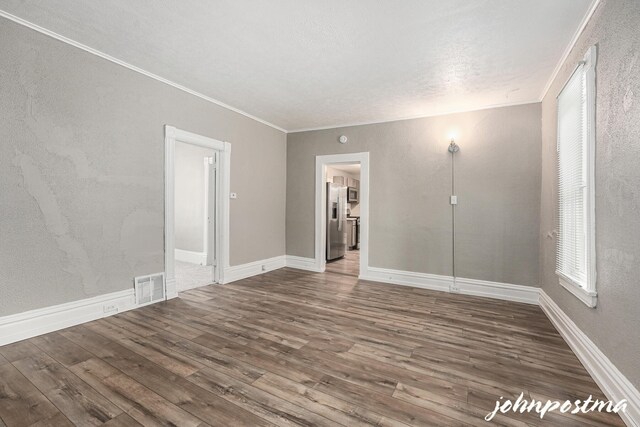 1108/1110 Muskegon Ave NW, Grand Rapids, MI 49504 - empty room with wood finished floors, a textured ceiling, visible vents, baseboards, and ornamental molding
