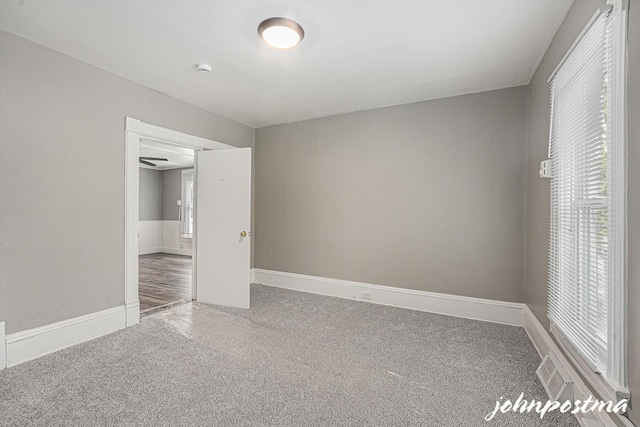 1108/1110 Muskegon Ave NW, Grand Rapids, MI 49504 - unfurnished bedroom featuring carpet, baseboards, visible vents, and multiple windows