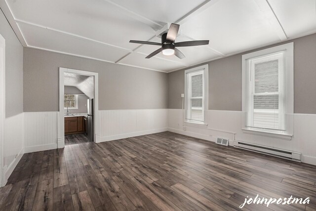 1108/1110 Muskegon Ave NW, Grand Rapids, MI 49504 - empty room featuring visible vents, wainscoting, ceiling fan, a baseboard heating unit, and dark wood-style floors