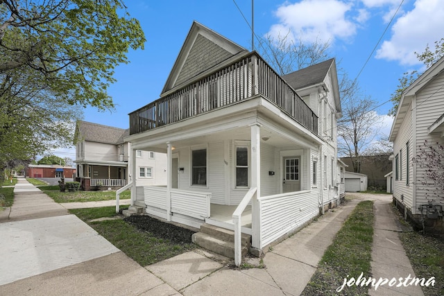 1108/1110 Muskegon Ave NW, Grand Rapids, MI 49504 - view of front of home featuring a porch, roof with shingles, an outdoor structure, a detached garage, and a balcony