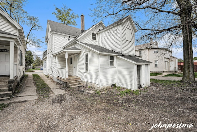 1108/1110 Muskegon Ave NW, Grand Rapids, MI 49504 - back of house featuring a shingled roof and a chimney