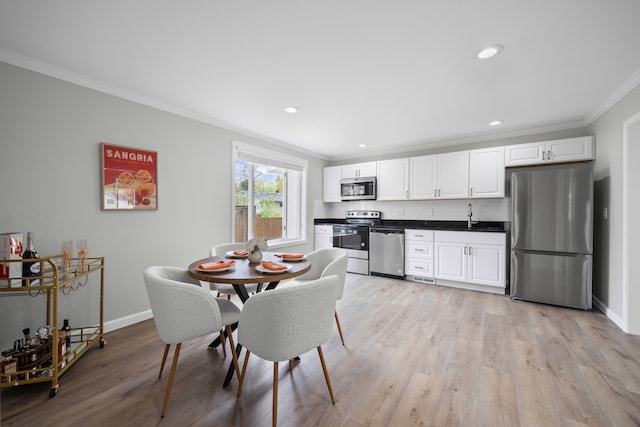 91 S Josephine Ave, Waterford, MI 48328 - dining room featuring crown molding, baseboards, light wood-type flooring, recessed lighting, and bar area