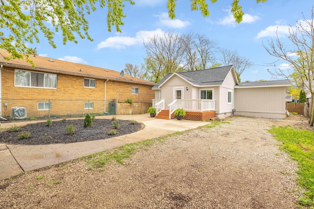 91 S Josephine Ave, Waterford, MI 48328 - back of house featuring fence, brick siding, a wooden deck, central air condition unit, and a patio
